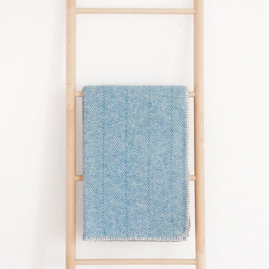 Baumwolldecke auf Leiter hängend in der Farbe Blau