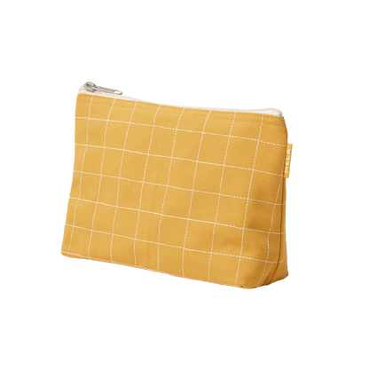 Gelbe Kosmetiktasche aus Baumwolle mit Reißverschluss vor weißem Hintergund
