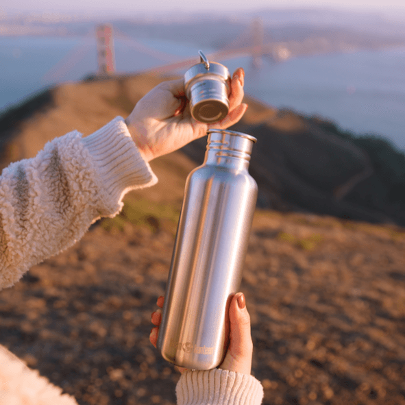 Person öffnet Edelstahl Trinkflasche mit Drehverschluss
