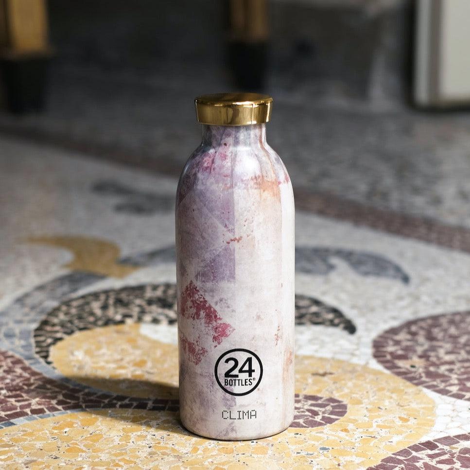 Edelstahl Trinkflasche im italienischen Villa Design mit goldenem Verschluss auf Mosaik Fußboden