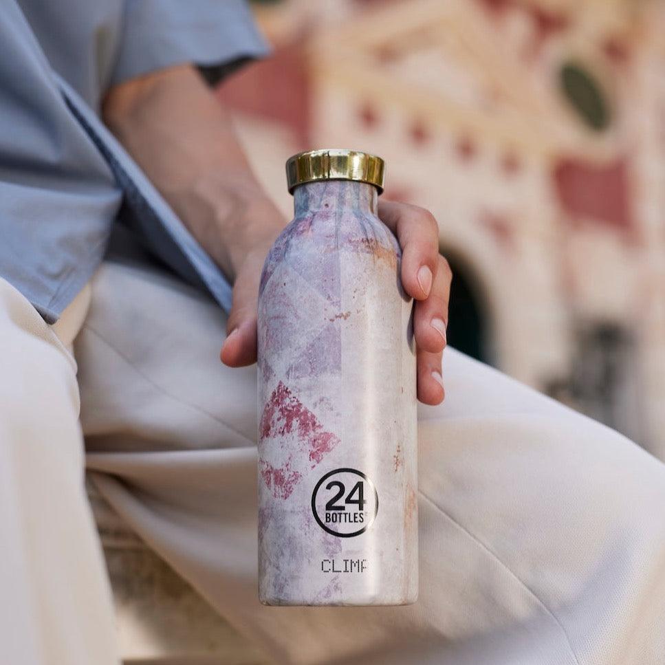 Edelstahl Trinkflasche im italienischen Villa Design mit goldenem Verschluss in Hand gehalten