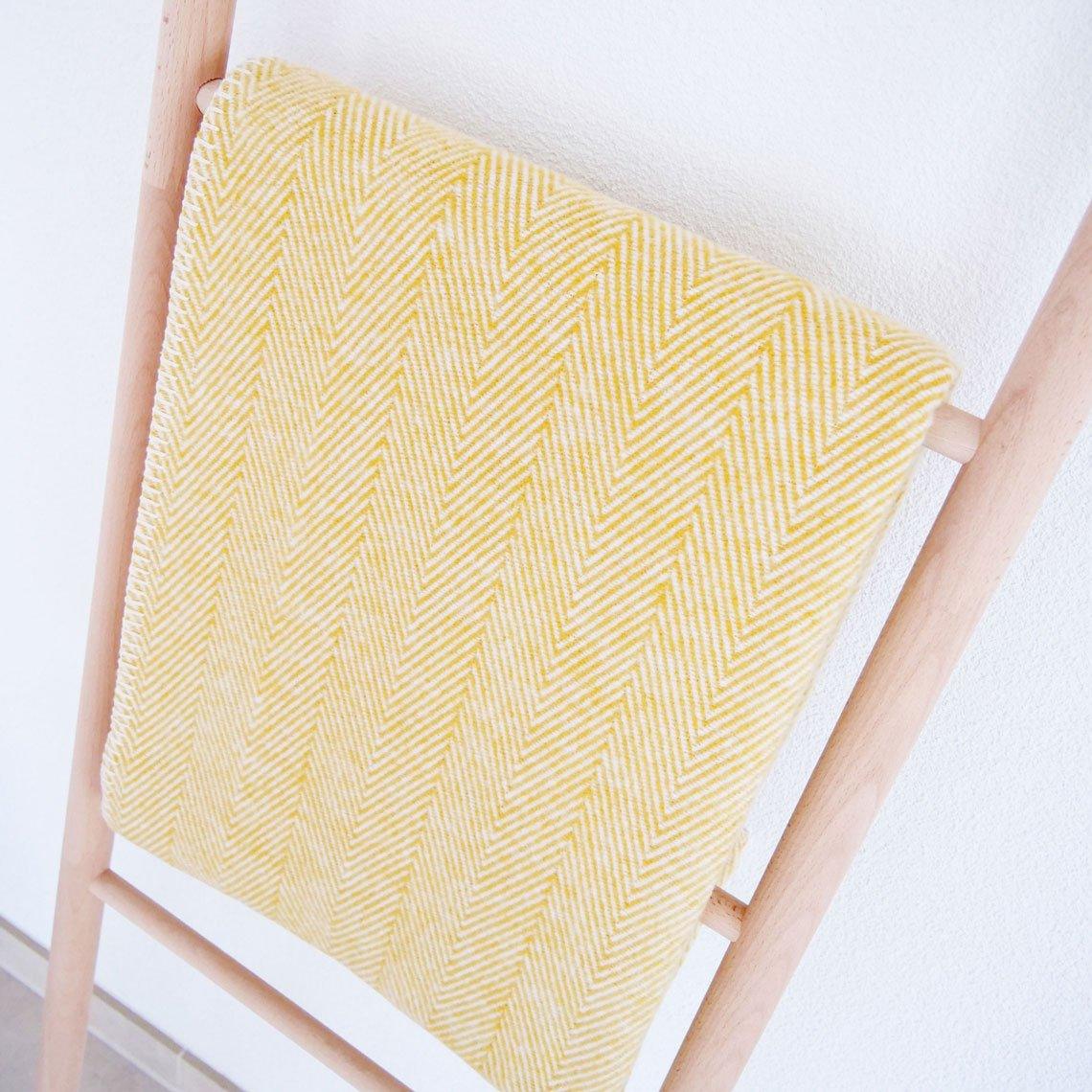 Baumwolldecke auf Leiter hängend in der Farbe gelb